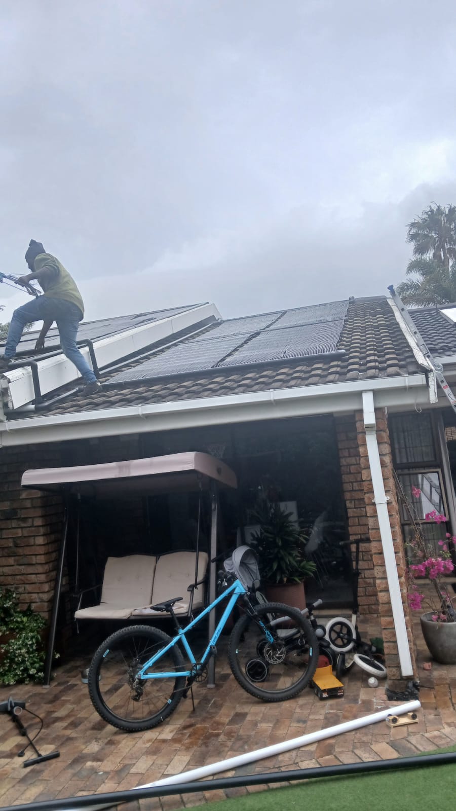Installer fitting collectors above a patio